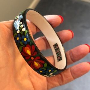 Enamel bangle bracelet in flower design on a black background